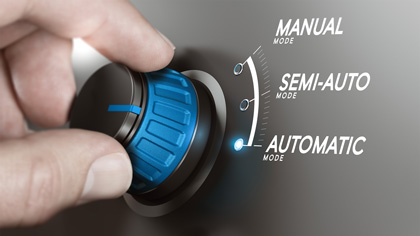 Detalhe de uma mão girando um botão com três estágios: Manual, Semi-automático e Automático